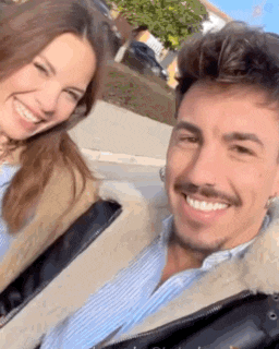 a man and a woman are smiling for a picture while sitting next to each other .