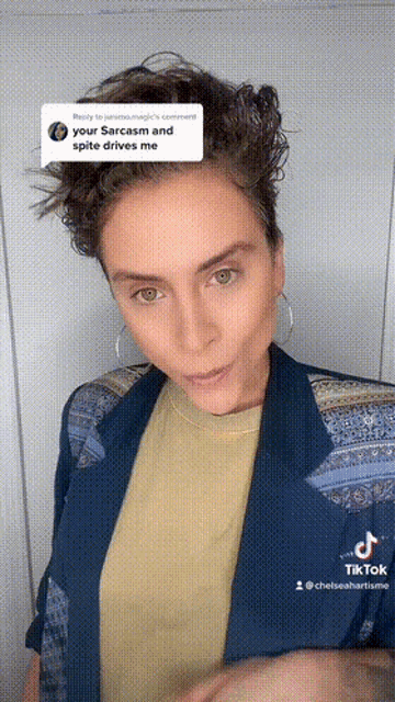 a woman wearing a blue jacket and a yellow t-shirt has a tiktok account