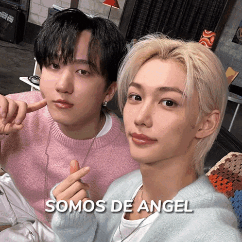 two young men are posing for a picture with the words somos de angel above them