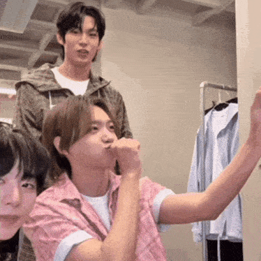 a man in a pink shirt is taking a picture of himself