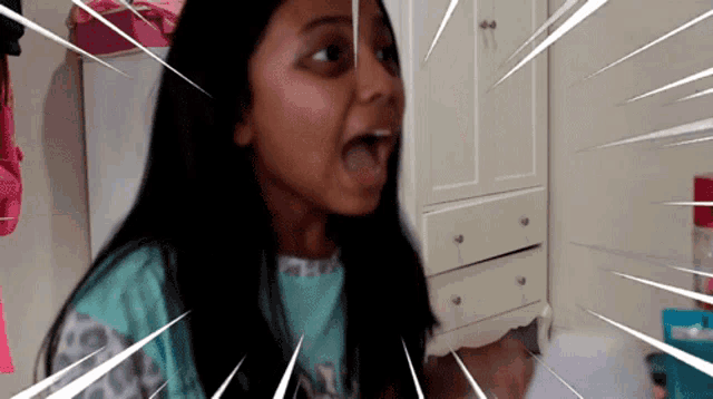 a girl with a surprised look on her face is in a room