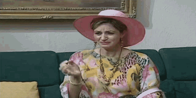 a woman in a pink hat sits on a couch