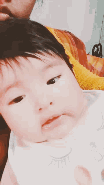 a close up of a baby 's face with a white bib on