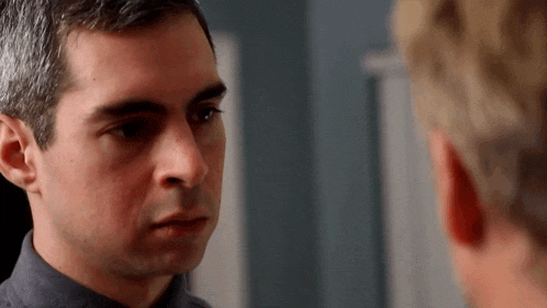 a man with gray hair is looking at another man with blonde hair
