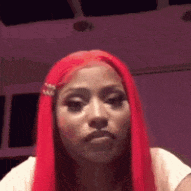 a woman with red hair is making a funny face in a room .