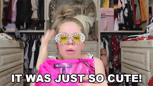 a woman wearing sunglasses holds a pink bag and says it was just so cute ..
