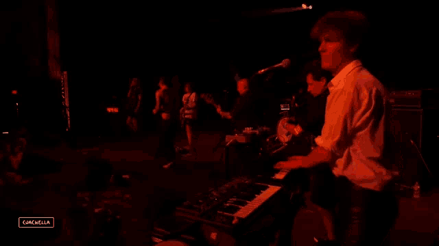 a man playing a keyboard on a stage with the word coachella on the bottom