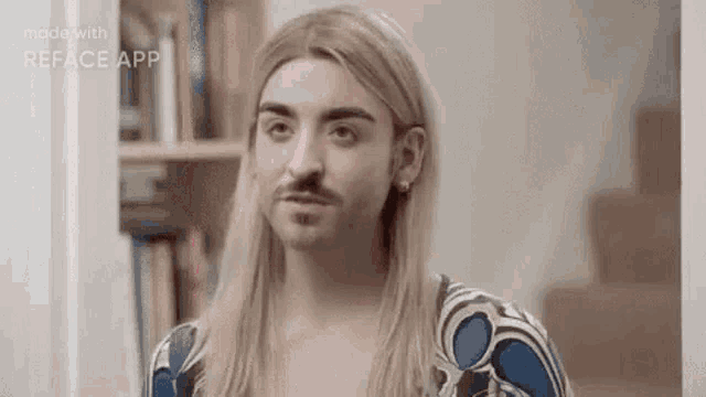 a man with long blonde hair and a beard is wearing a wig and earrings .