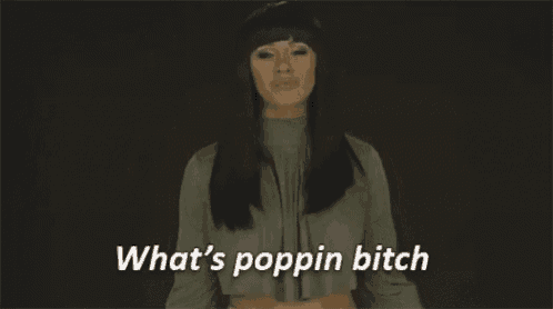 a woman is standing in front of a black background and says `` what 's poppin bitch ''