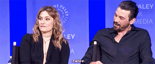 a man and a woman are sitting in front of a wall that says paley
