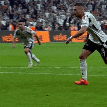 soccer players on a field with a sign that says nescafe