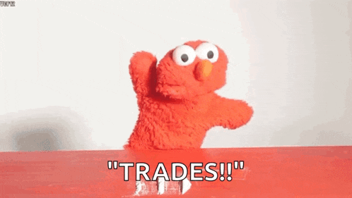 elmo from sesame street is standing on a red table and saying " trades !!! "