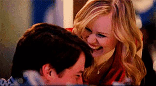 a man and a woman are laughing together and the woman is smiling at the man