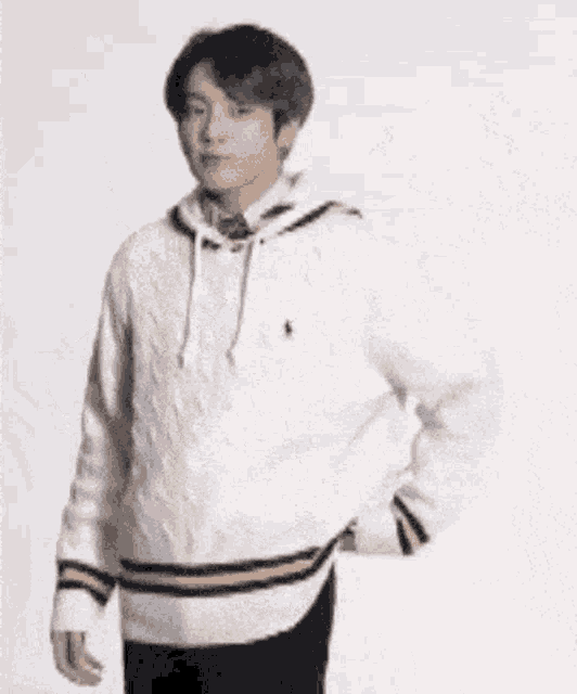 a blurry picture of a person wearing a hoodie and holding a purse .