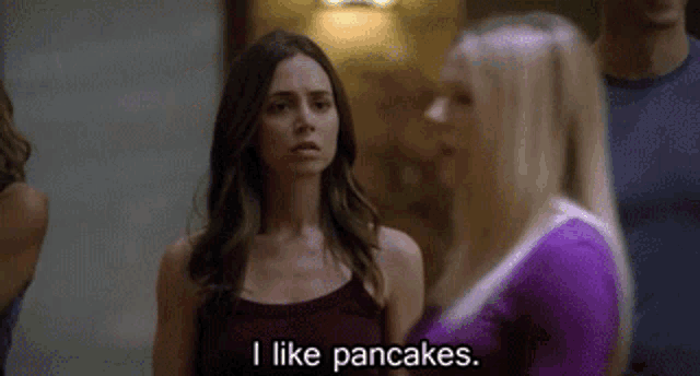 a woman says i like pancakes in front of a group of people