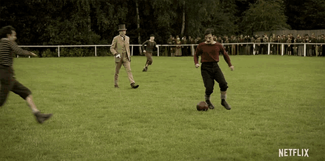 a group of men playing soccer on a field with a netflix logo in the corner