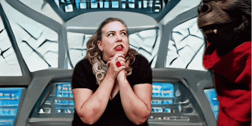a woman with a red ring on her finger prays in front of a screen that says ' e ' on it