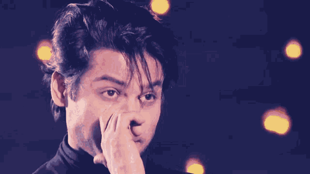 a close up of a man 's face with his hand on his chin