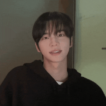 a young man wearing a black hoodie looks at the camera