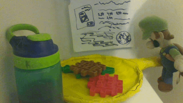 a green water bottle sits next to a stuffed mario and a yellow plate