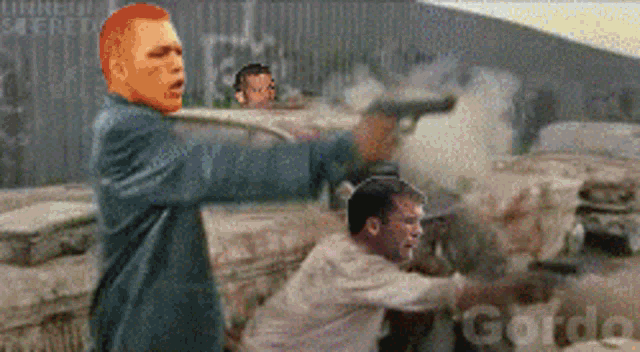 a man with a red head is holding a gun in a blurry photo with the word gordo in the corner