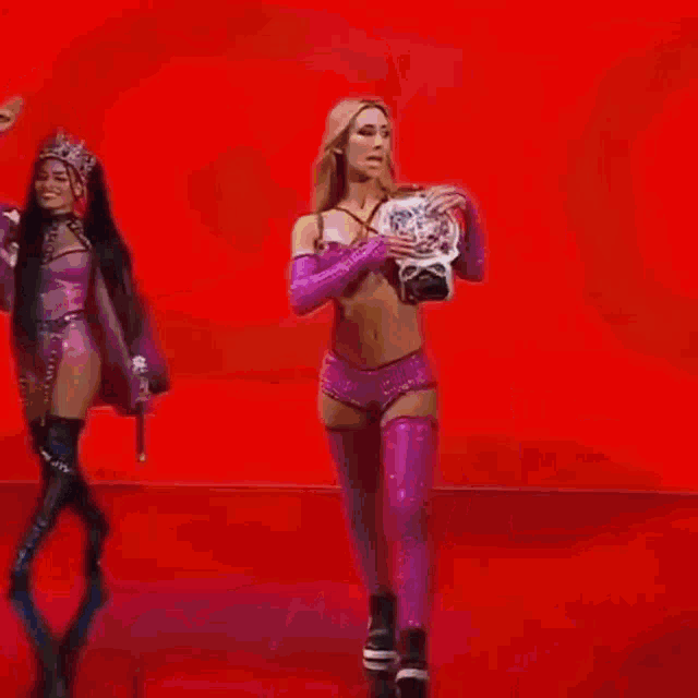 two women in bikinis are standing next to each other in a ring .