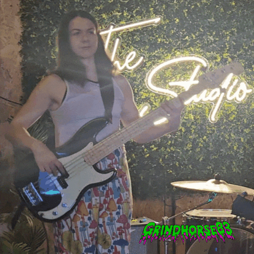 a woman is playing a guitar in front of a neon sign that says the fujo