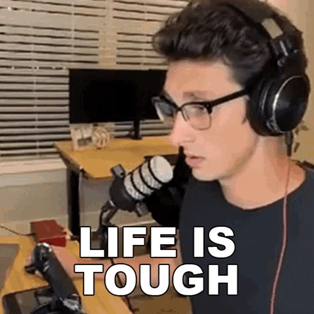 a man wearing glasses and headphones says " life is tough "