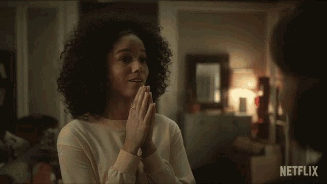 a woman clapping her hands in front of a sign that says " thank you "