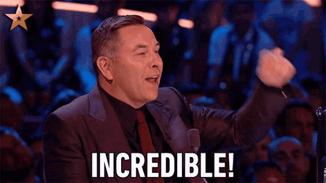 a man in a suit and tie is saying incredible in front of a crowd