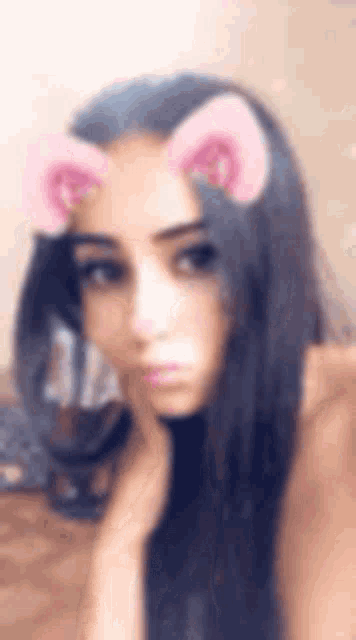 a close up of a woman wearing a cat ear filter on her face .