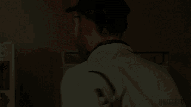 a man with a bandage on his eye is standing in a dark room with the word unabridged below him