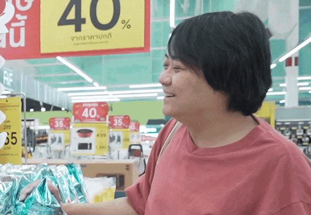 a woman in a red shirt is standing in front of a sign that says 40 %