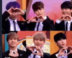 a group of young men are making a heart shape with their hands .