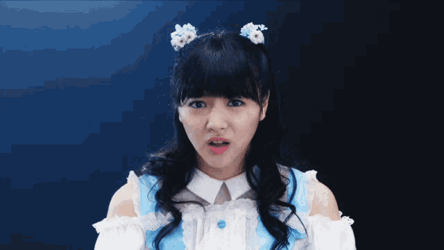 a girl wearing a blue and white dress making a funny face