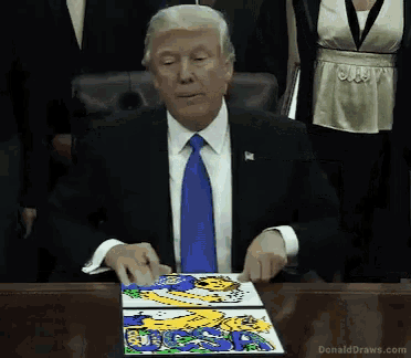 donald trump is sitting at a desk with a drawing of a tiger on it