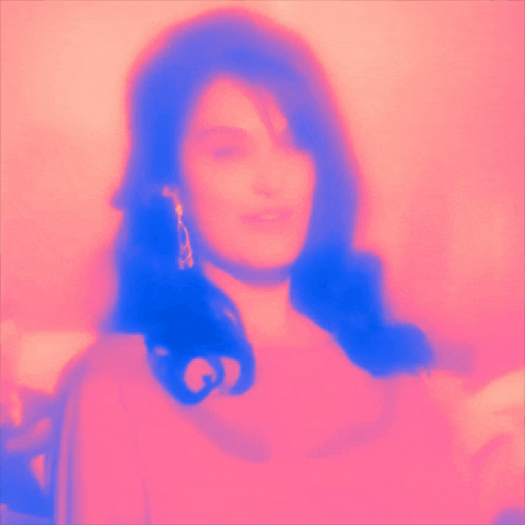 a blurred image of a woman 's face with a pink and blue background