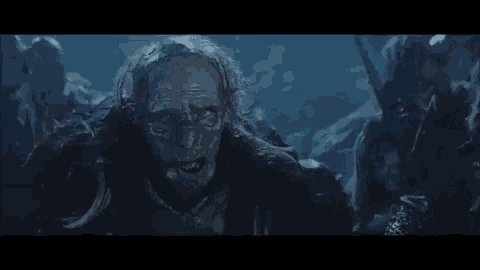 a group of orcs are standing in a dark cave .