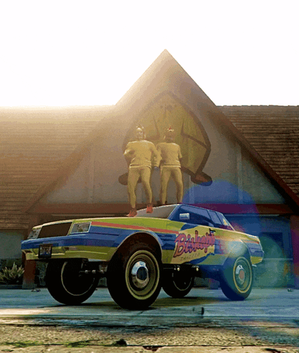 two men standing on top of a yellow and blue car that says bigfoot