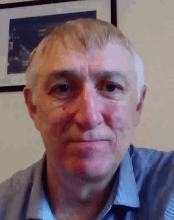 a man in a blue shirt is looking at the camera