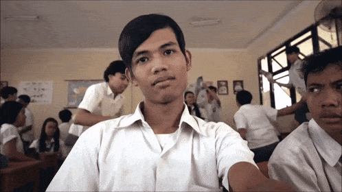 a group of students in a classroom with a poster on the wall that says ' a ' on it