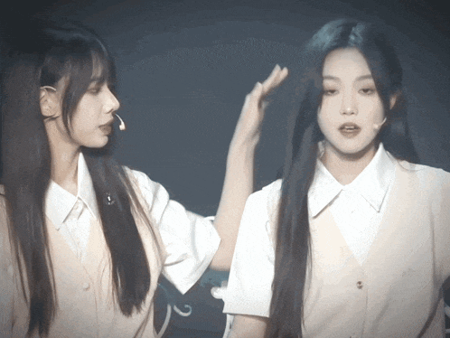 two girls are standing next to each other and one of them has a microphone in her ear