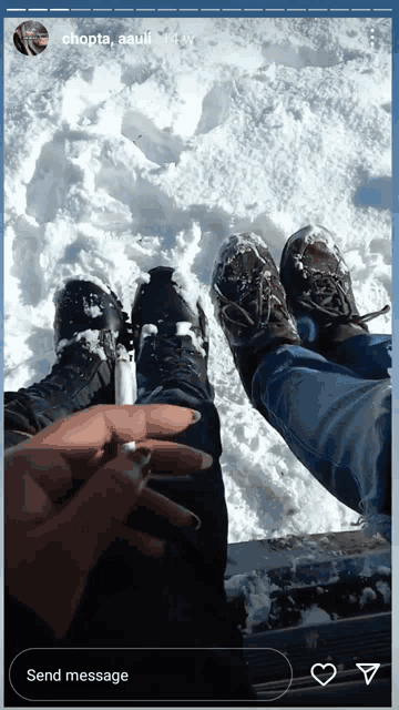 a person is holding a lighter in their hand while laying in the snow with their feet in the snow
