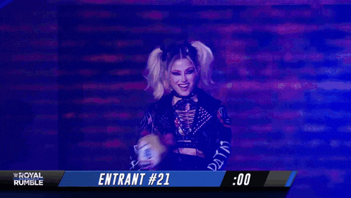 a woman is holding a stuffed animal and the name alexa bliss is on the screen behind her