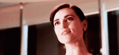 a close up of a woman 's face with a smile on her face and a serious look on her face .