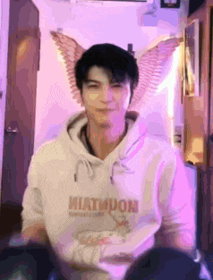 a young man wearing a white hoodie with the word miatimuon on it