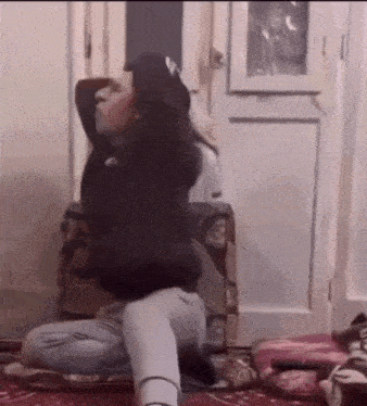 a person is kneeling down in front of a door with their arms outstretched