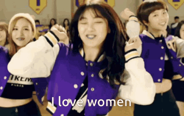 a girl in a purple jacket says i love women while dancing