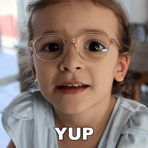 a little girl wearing glasses has the word yup written on the bottom of her face
