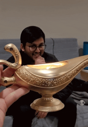 a man holding a gold lamp with a snake on the handle
